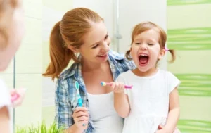 child with mother cleaning teeth child with mother cleaning teeth